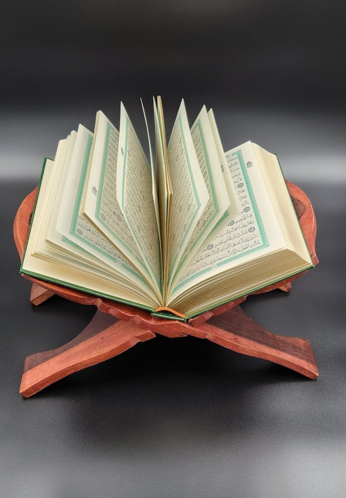An open Quran displayed on a wooden stand, perfect for spiritual study.